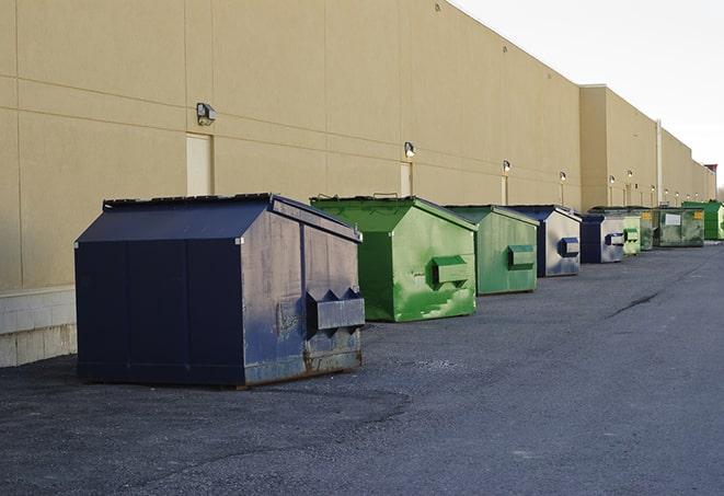 a row of yellow and blue dumpsters at a construction site in Bristol